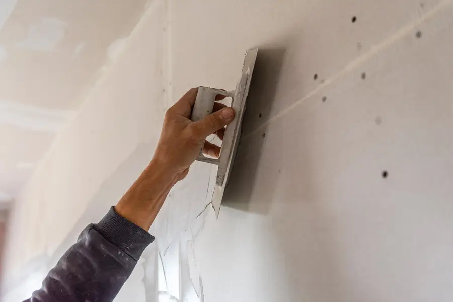 Handwerker glättet eine Wand bei einer baulichen Maßnahme